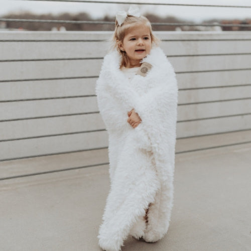 Small child wrapped in BIG LOViE Little Angel Plush blanket in whisper white.