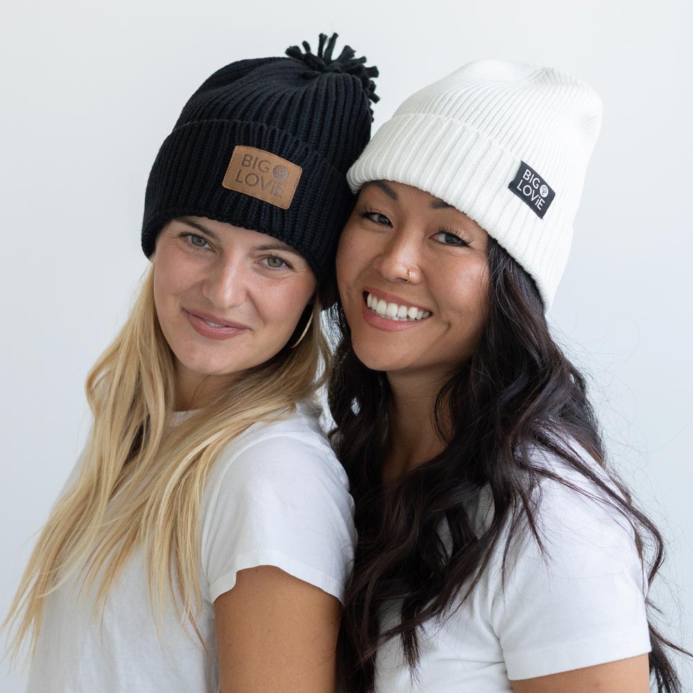BIG LOViE Vibe Black Cotton Cashmere Hat with Pom and Badass Ivory Beanie on smiling women