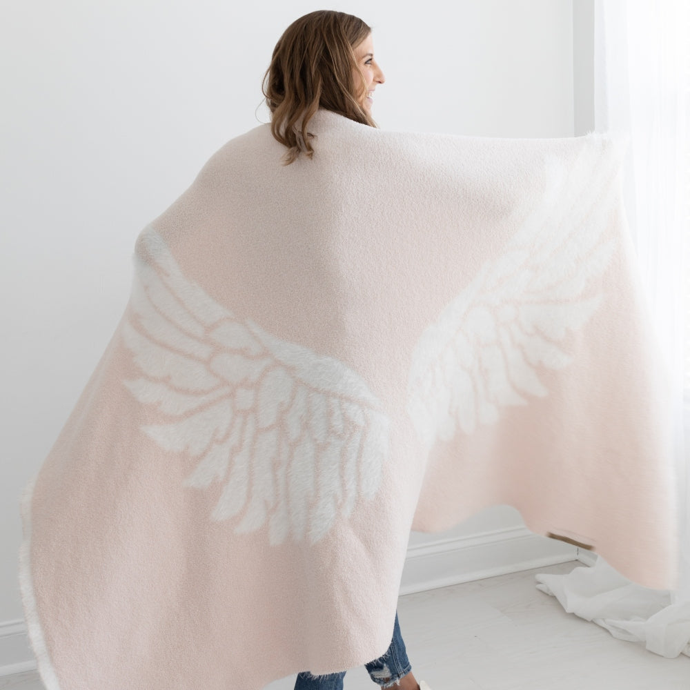 Woman wearing BIG LOViE Dreams collection Wings blanket in pink.