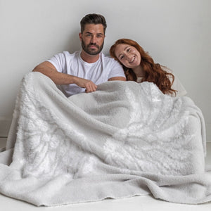 Couple wrapped in BIG LOViE Dream collection Wings blanket in Silver.