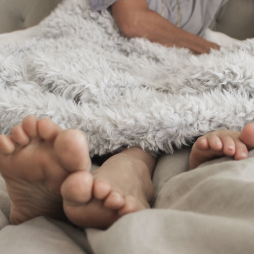 A  father and his baby's toes popping out of their Big Guardian Angel Blanket in Silver Cloud