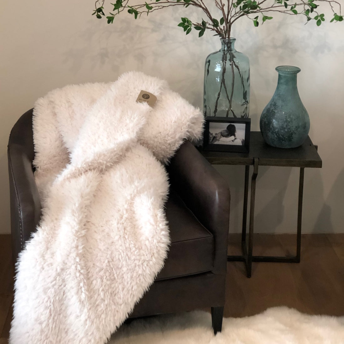 BIG LOViE Whisper White Guardian Angel Blanket draped over leather chair