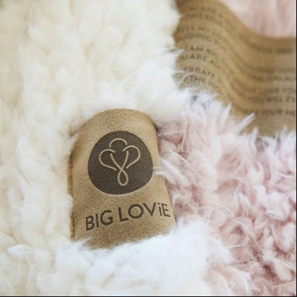 Close up of a Love Snap label with text, on Guardian Angel Blanket, fluffy llama fabric details