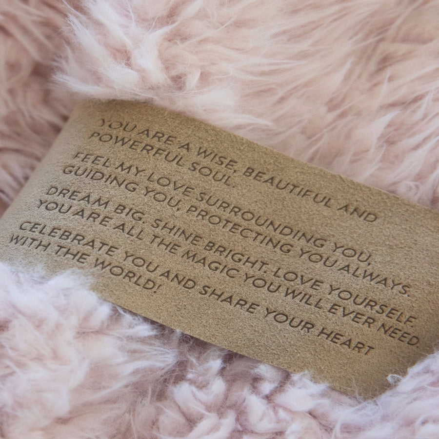 Close up of a Love Snap label with text, on a Dusty Pink Guardian Angel Blanket