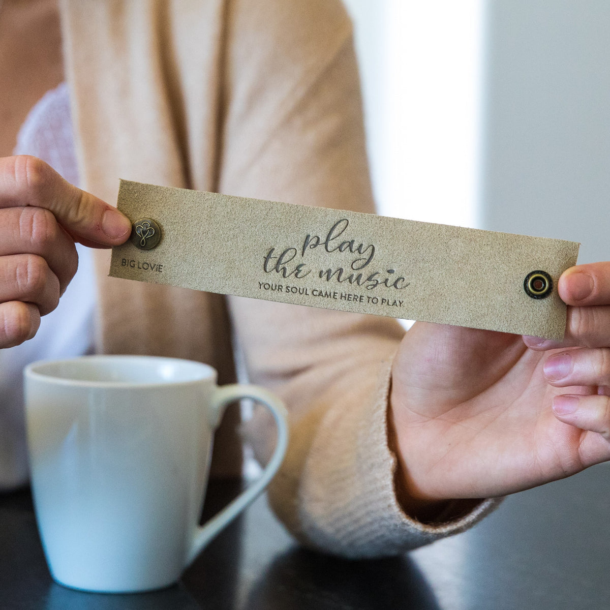 Woman with coffee, holding up LoveSnap